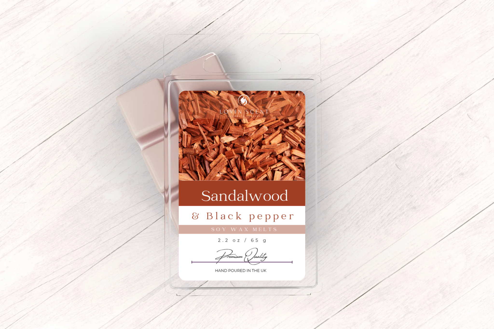 Sandalwood and black pepper wax melt packaging on a light wooden surface