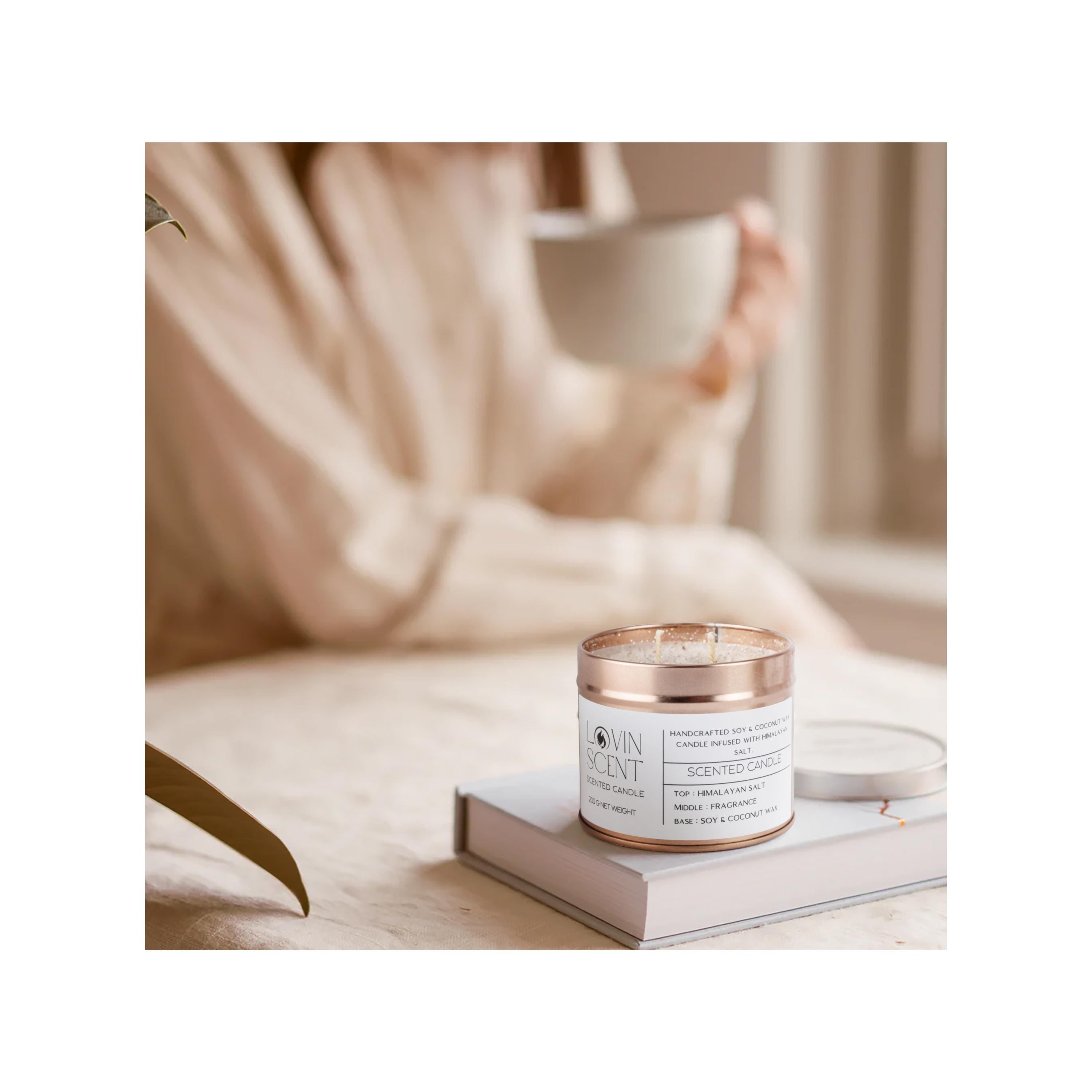 Candle with rose gold lid on a book, blurred background