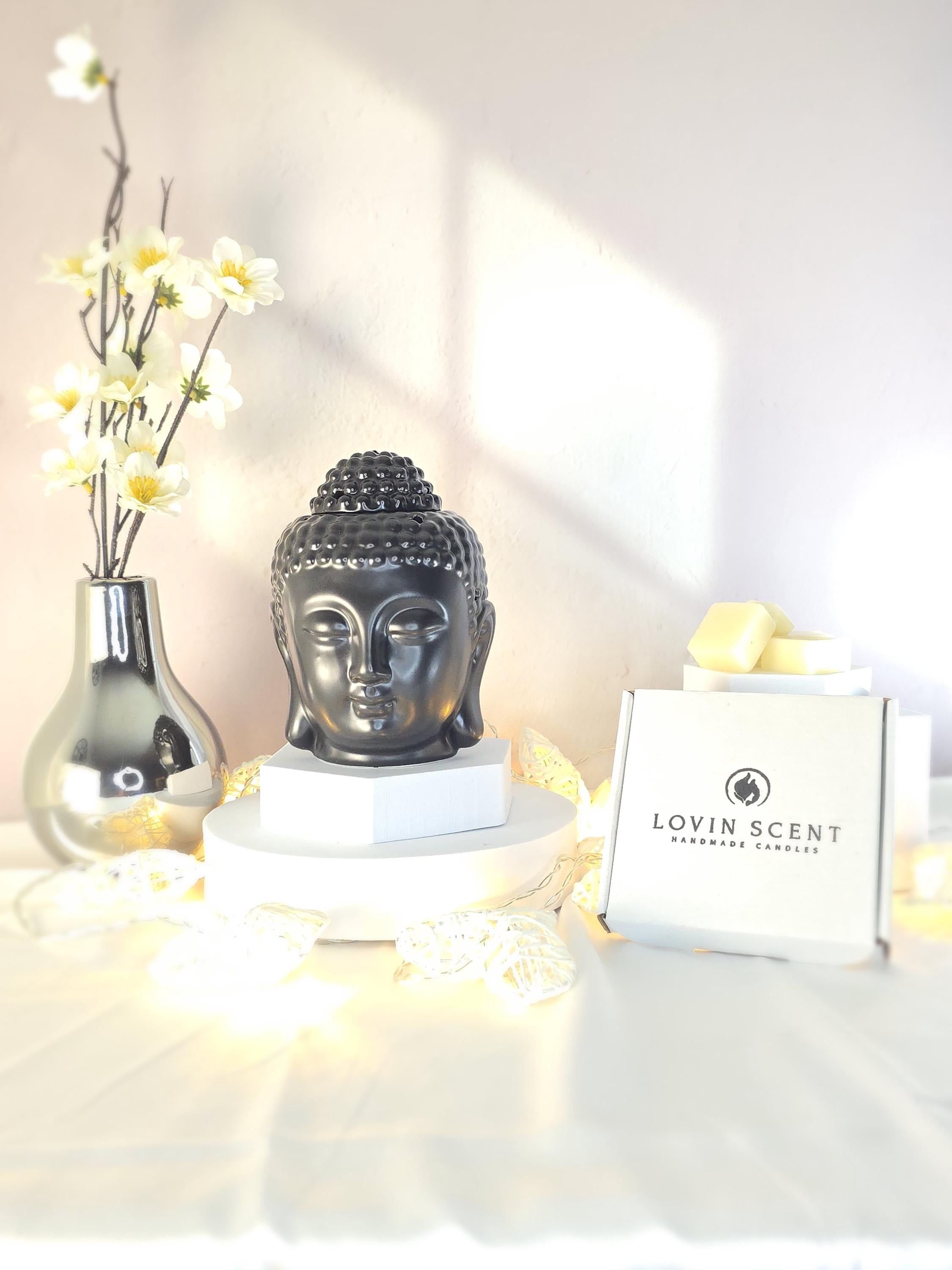Decorative setup with a Buddha statue, flowers, and a box labeled 'Lovin Scent' on a soft background.