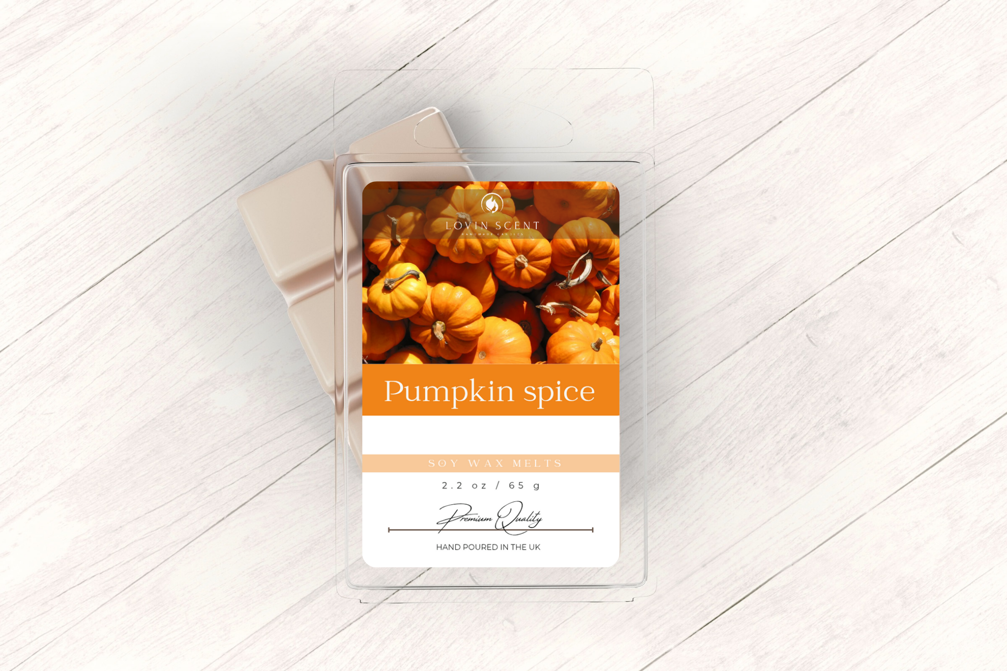 Pumpkin spice candle packaging with pumpkins on a white wooden surface