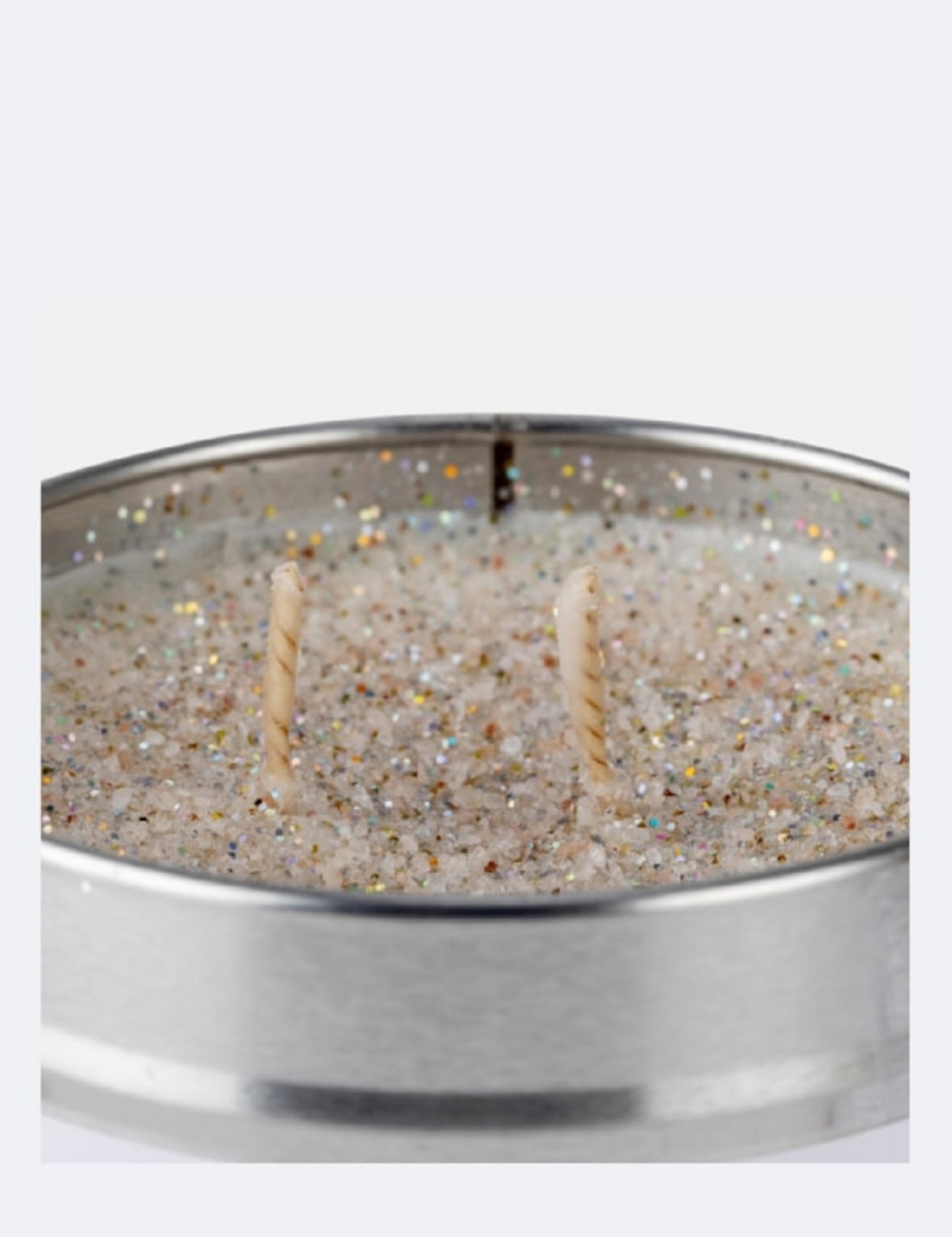 Candle in a metallic tin with glittery texture on a white background