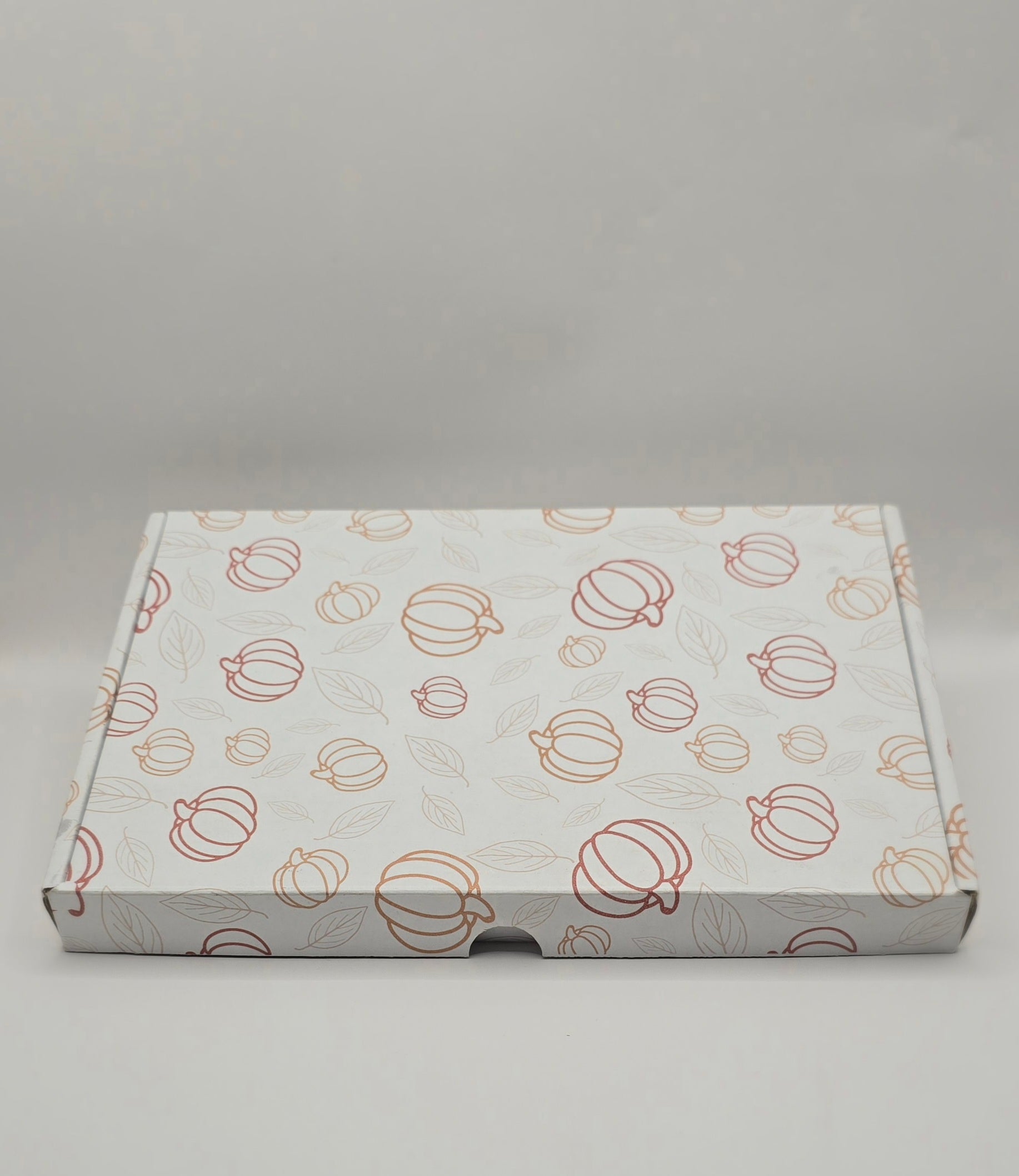 Cardboard box with pumpkin pattern on a gray background