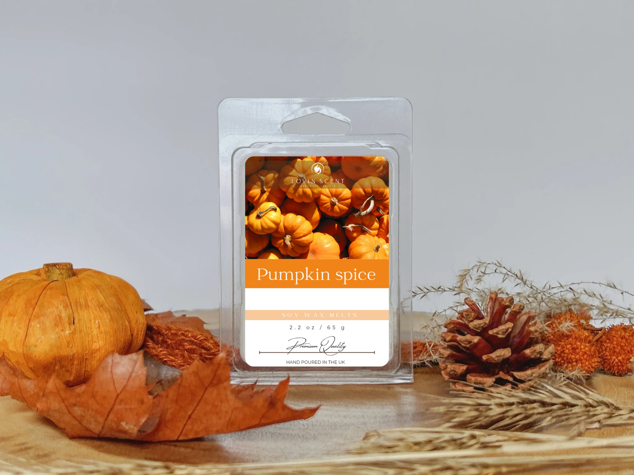 Pumpkin spice wax melt with pumpkins and leaves on a wooden surface