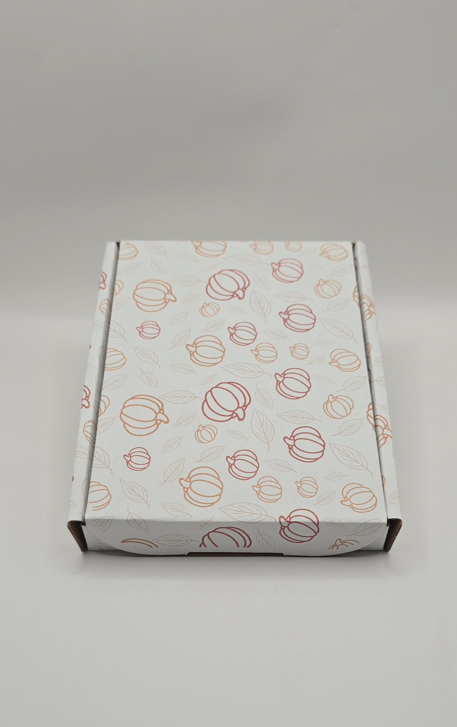 White box with pumpkin pattern on a gray background