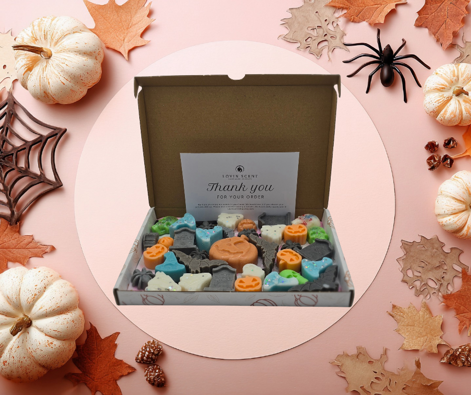Box of Halloween-themed soap bars with decorative pumpkins and leaves on a pink background