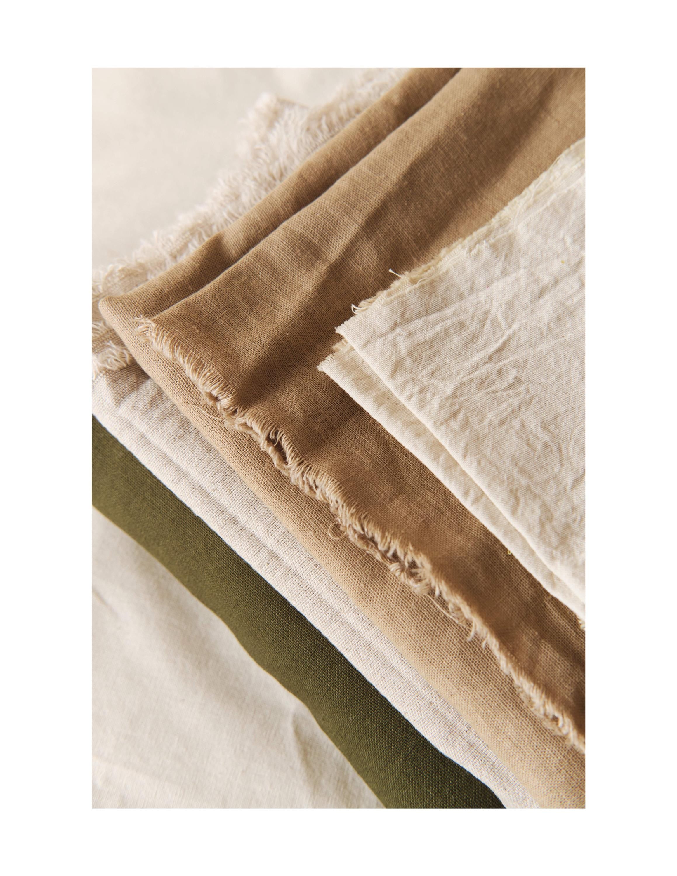 Stack of fabric swatches in brown, beige, and green on a white background